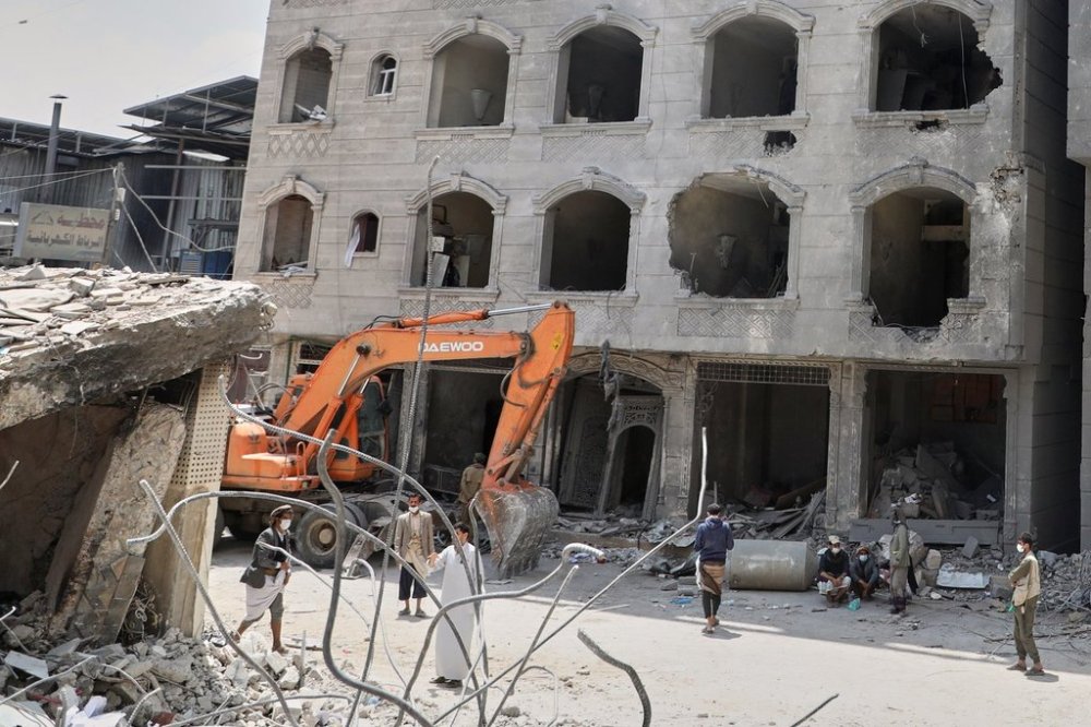 People gather at a damaged building following Israeli airstrikes in Sanaa, Yemen, Friday, Sept. 26, 2025. (AP Photo)