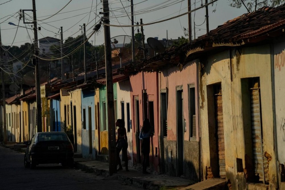 FILE - Residents walk along a sidewalk in Aracuai, Brazil, Oct. 11, 2022. (AP Photo/Andre Penner, File)