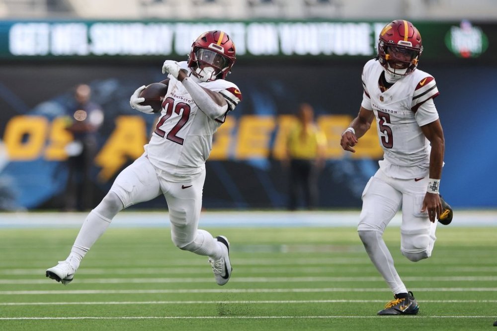 Washington Commanders running back Jacory Croskey-Merritt (22) runs in front of quarterback Jayden Daniels (5) during the second half of an NFL football game against the Los Angeles Chargers, Sunday, Oct. 5, 2025, in Inglewood, Calif. (AP Photo/Eric Thayer)