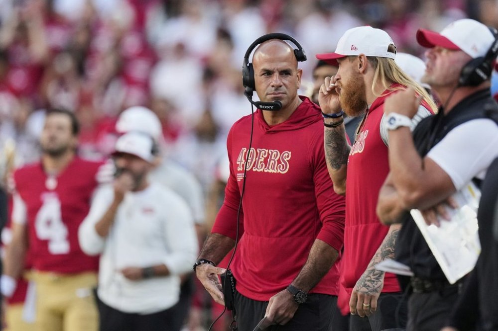 FILE - San Francisco 49ers tight end George Kittle, second from right, takes a whiff of a smelling salt stick next to defensive coordinator Robert Saleh, middle, on the sideline during the first half of an NFL preseason football game against the Los Angeles Chargers, Saturday, Aug. 23, 2025, in Santa Clara, Calif. (AP Photo/Godofredo A. Vásquez, File)