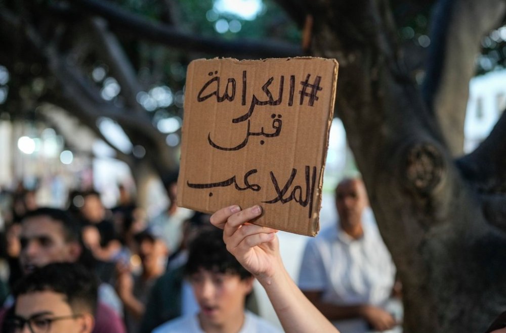 People take part in a youth-led protest against corruption and calling for healthcare and education reform in Rabat, Morocco, Friday, Oct. 3, 2025. The sign reads,