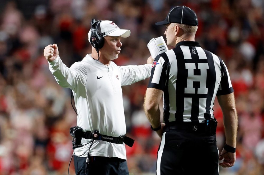 Virginia Tech interim head coach Philip Montgomery talks with an official during the second half of an NCAA college football game against North Carolina State in Raleigh, N.C., Saturday, Sept. 27, 2025. (AP Photo/Karl DeBlaker)