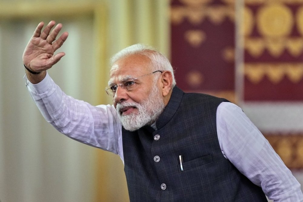 Indian Prime Minister Narendra Modi waves to his supporters during a public rally at Mangaldoi, north of Guwahati, India, on Sunday, Sept. 14, 2025. (AP Photo/Anupam Nath)