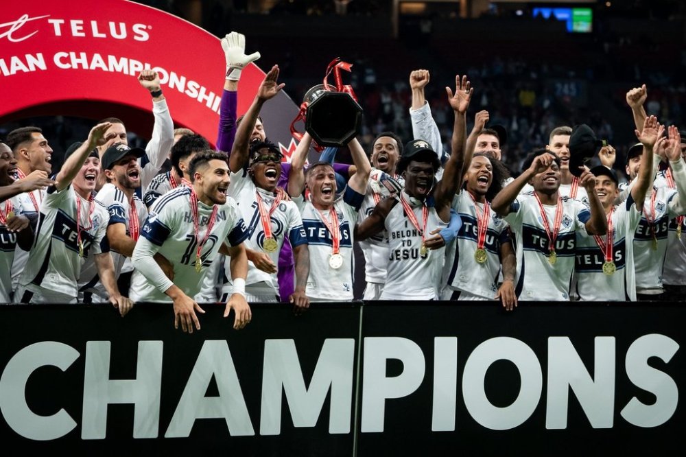 Vancouver Whitecaps' Ryan Gauld, centre, hoists the Voyageurs Cup with his team after defeating Vancouver FC in the Canadian Championship final soccer match in Vancouver, on Wednesday, October 1, 2025. THE CANADIAN PRESS/Ethan Cairns
