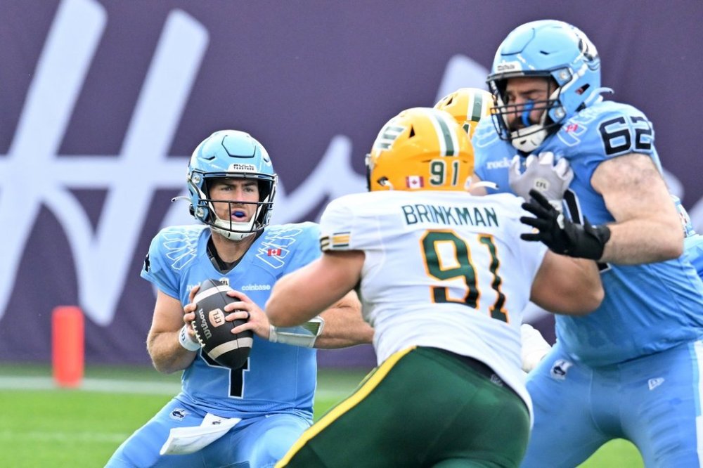 Toronto Argonauts quarterback Nick Arbuckle (4) scrambles under pressure from Edmonton Elks' defensive lineman Jared Brinkman (91) during first half CFL football action in Toronto, Saturday, Sept. 13, 2025. THE CANADIAN PRESS/Jon Blacker