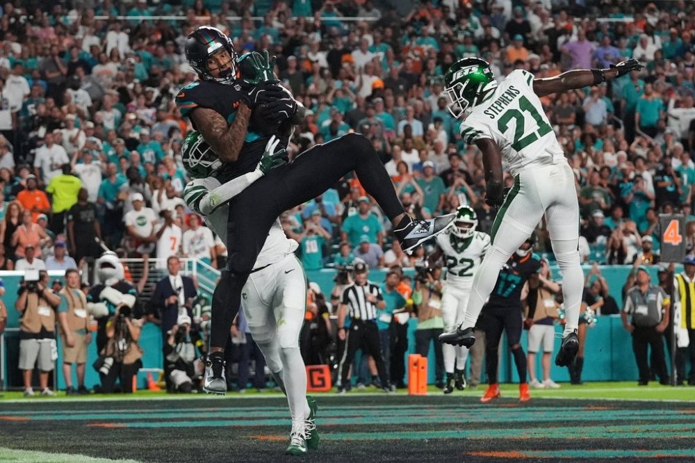 Miami Dolphins tight end Darren Waller (83) catches a touchdown pass as New York Jets' Sauce Gardner, rear, and Brandon Stephens (21) defend in the first half of an NFL football game, Monday, Sept. 29, 2025, in Miami Gardens, Fla. (AP Photo/Marta Lavandier)