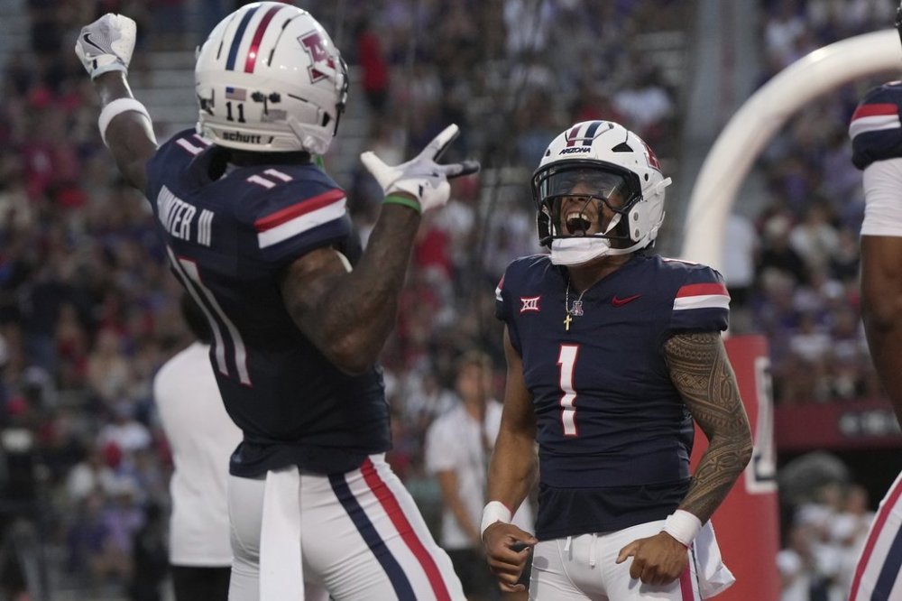 Arizona quarterback Noah Fifita (1) celebrates with wide receiver Chris Hunter, left, after scoring a touchdown against Kansas State in the first half of an NCAA college football game, Friday, Sept 12, 2025, in Tucson, Ariz. (AP Photo/Rick Scuteri)