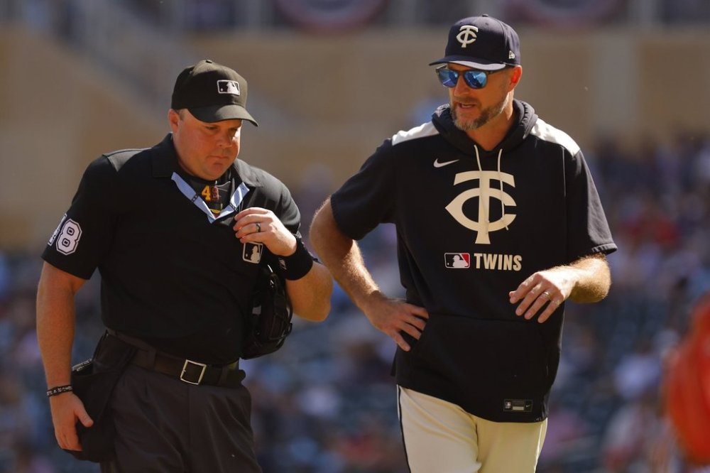 Minnesota Twins manager Rocco Baldelli speaks with home plate umpire Nick Mahrley, left, after a runner's interference call was awarded to the Cleveland Guardians on a play in the first inning of a baseball game Sunday, Sept. 21, 2025, in Minneapolis. (AP Photo/Bruce Kluckhohn)