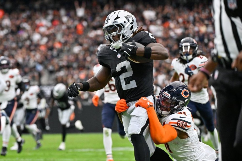 Las Vegas Raiders running back Ashton Jeanty (2) is grabbed by Chicago Bears free safety Kevin Byard (31) as he runs toward the end zone for a touchdown during the first half of an NFL game, Sunday, Sept. 28, 2025, in Las Vegas. (AP Photo/David Becker)