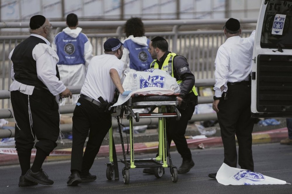 Israeli Zaka rescue and recovery team carry the body of a victim at the scene of shooting attack carried out by two Palestinian gunmen, in which several people were killed and others injured at a bus stop in Jerusalem, Monday, Sept. 8, 2025. (AP Photo/Mahmoud Illean)