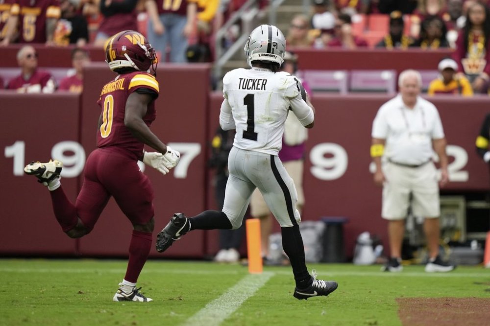 Las Vegas Raiders wide receiver Tre Tucker (1) scores a touchdown as Washington Commanders cornerback Mike Sainristil (0) defends during the second half of an NFL football game Sunday, Sept. 21, 2025, in Landover, Md. (AP Photo/Stephanie Scarbrough)