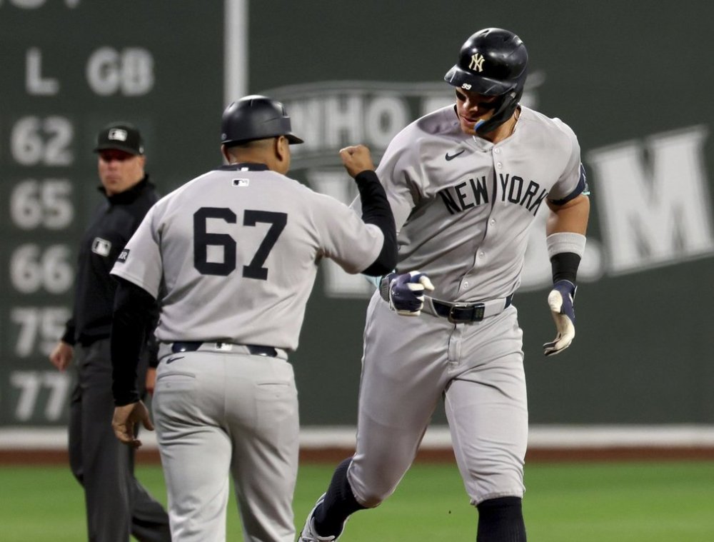 New York Yankees designated hitter Aaron Judge, right, fist-bumps third base coach Luis Rojas (67) after hitting a home run during the first inning of a baseball game against the Boston Red Sox, Friday, Sept. 12, 2025, in Boston. (AP Photo/Mark Stockwell)