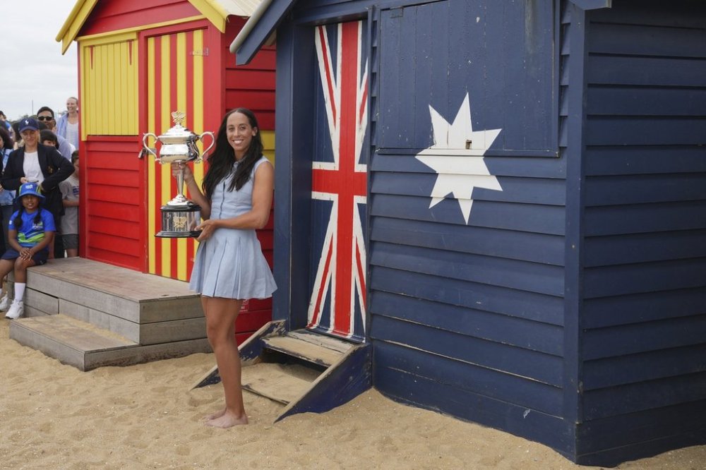 FILE- Madison Keys of the U.S. holds the Daphne Akhurst Memorial Cup at the Brighton Beach Boxes the morning after defeating Aryna Sabalenka of Belarus in the women's singles final at the Australian Open tennis championship in Melbourne, Australia, Sunday, Jan. 26, 2025. (AP Photo/Vincent Thian,File)
