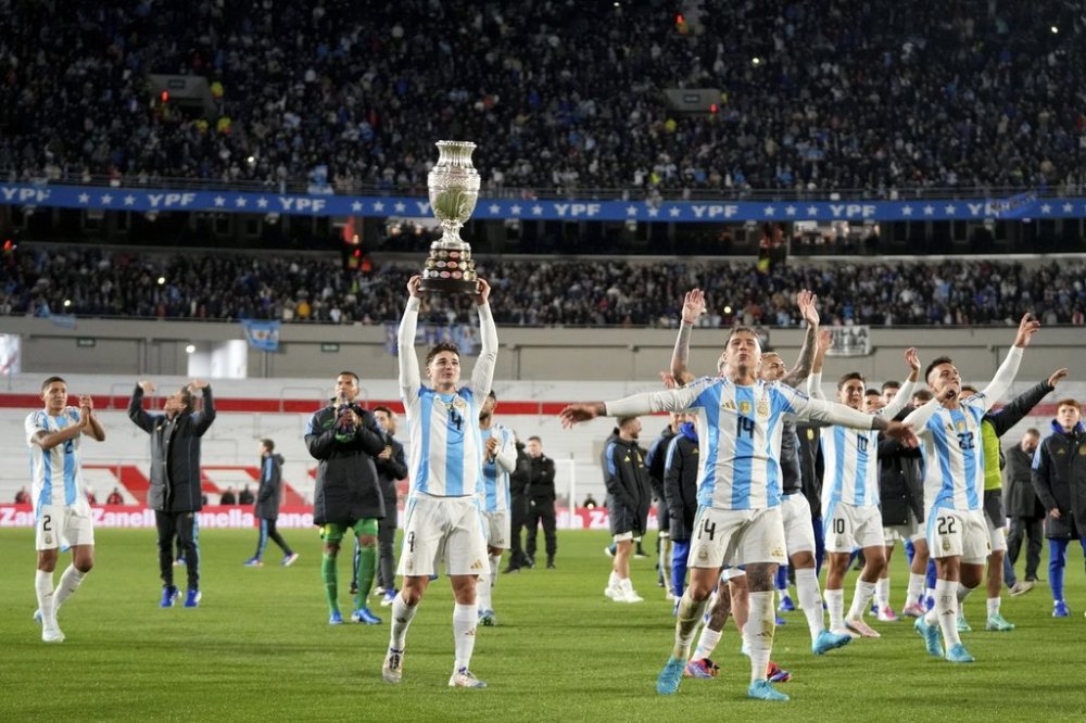 Argentina's Julian Alvarez hoists the 2024 Copa America trophy after a qualifying soccer match for the FIFA World Cup 2026 against Chile in Buenos Aires, Argentina, Thursday, Sept. 5, 2024. (AP Photo/Natacha Pisarenko)