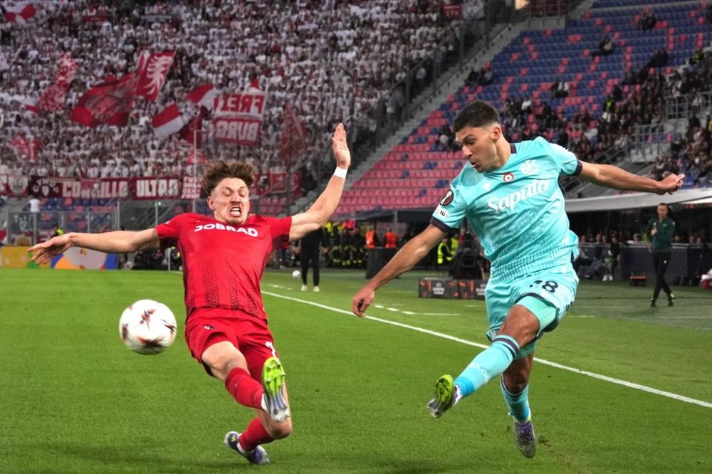 Bologna's Nicolo Cambiaghi, right, kicks the ball past Freiburg's Philipp Treu during the Europa League, opening phase soccer match between Bologna and Freiburg at the Renato Dall'Ara Stadium in Bologna, Italy, Thursday, Oct. 2, 2025. (Massimo Paolone/LaPresse via AP)