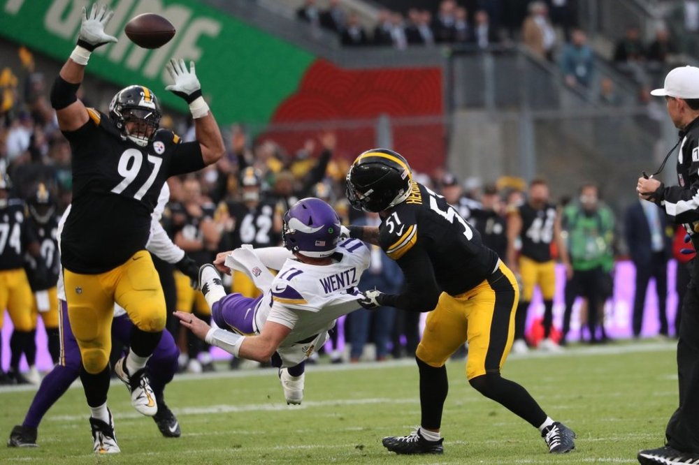 Pittsburgh Steelers defensive tackle Cameron Heyward (97), left, Pittsburgh Steelers linebacker Nick Herbig (51) and Minnesota Vikings quarterback Carson Wentz (11),center, challenge for the ball during the NFL football game between Minnesota Vikings and Pittsburgh Steelers at Croke Park stadium in Dublin, Sunday, Sept. 28, 2025.(AP Photo/Peter Morrison)