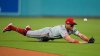 Cincinnati Reds second baseman Matt McLain cannot make a diving stop on a single from Los Angeles Dodgers' Max Muncy during the fourth inning in Game 2 of the National League Wild Card baseball playoff series Wednesday, Oct. 1, 2025, in Los Angeles. (AP Photo/Mark J. Terrill)