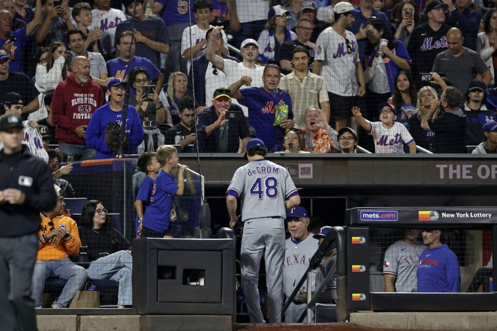 Fans cheer as Texas Rangers pitcher Jacob deGrom (48) walks into the dugout during the seventh inning of a baseball game against the New York Mets, Friday, Sept. 12, 2025, in New York. (AP Photo/Adam Hunger)