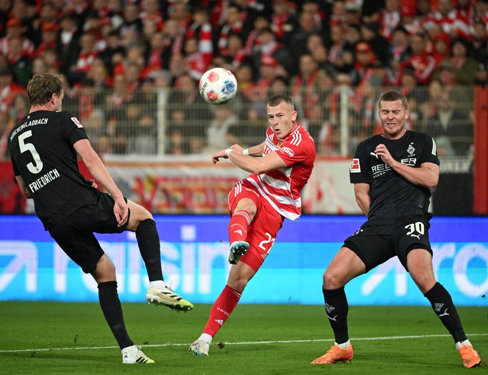Moenchengladbach's Nico Elvedi, right and Marvin Friedrich in action against Union's Tim Skarke during the German Bundesliga soccer match between 1. FC Union Berlin and Borussia Moenchengladbach in Berlin, Friday, Oct. 17, 2025. (Soeren Stache/dpa via AP)