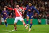Leipzig's Tidiam Gomis, right, and Cottbus' Dominik Pelivan, left, challenge for the ball during a German soccer cup second round match between Energie Cottbus and RB Leipzig in Cottbus, Germany, Tuesday, Oct. 28, 2025. (Robert Michael/dpa via AP)