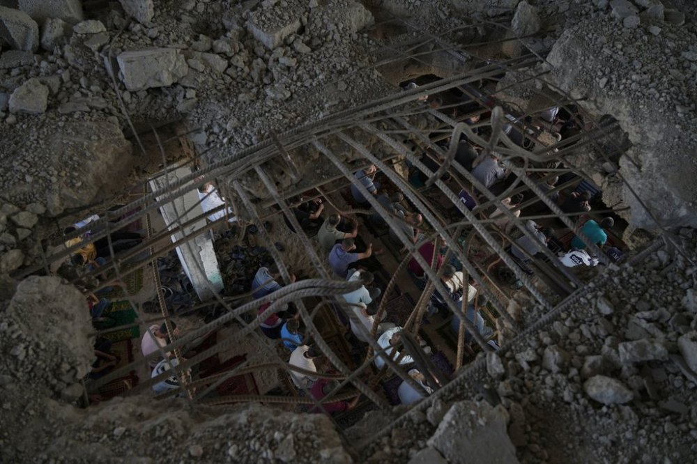 Palestinians gather for Friday prayers amid the rubble of a destroyed building in Khan Younis, in the southern Gaza Strip, Friday, Oct. 17, 2025. (AP Photo/Jehad Alshrafi)
