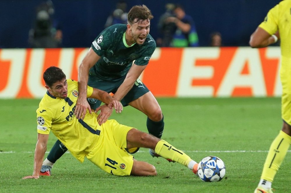 Villarreal's Santi Comesana, bottom left, challenges for the ball with Manchester City's Nico Gonzalez during the Champions League opening phase soccer match between Villarreal and Manchester City in Villarreal, Spain, Tuesday, Oct. 21, 2025. (AP Photo/Alberto Saiz)