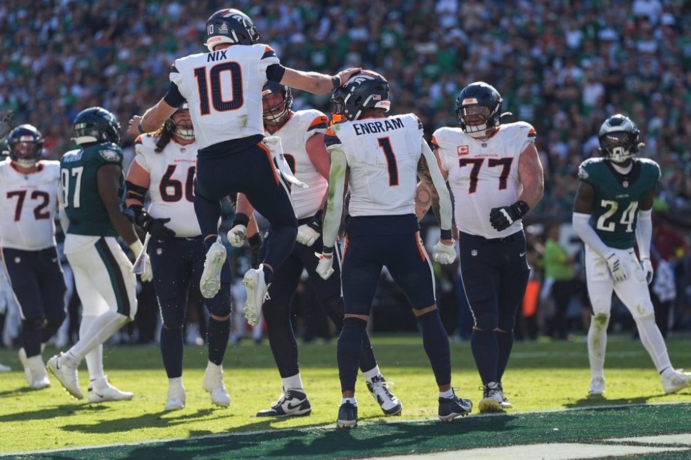 Denver Broncos quarterback Bo Nix (10) celebrates after Broncos tight end Evan Engram (1) scores a touchdown during the second half of an NFL football game against the Philadelphia Eagles on Sunday, Oct. 5, 2025, in Philadelphia. (AP Photo/Matt Rourke)