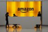 FILE - People stand in the lobby for Amazon offices in New York, Feb. 14, 2019. (AP Photo/Mark Lennihan, File)