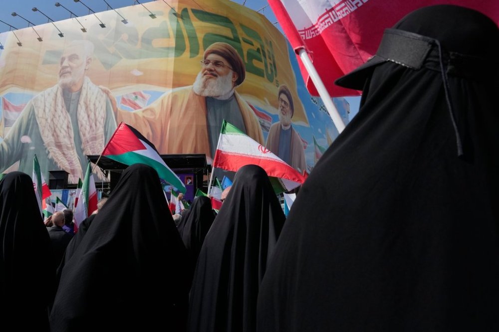Iranian worshippers wave Palestinian and Iranian flags in front of a banner showing the late commander of the Iran's Revolutionary Guard expeditionary Quds Force, Gen. Qassem Soleimani, left, and two late Hezbollah leaders Hassan Nasrallah, center, and Hashem Safieddine, during an anti-Israeli rally after the Friday prayers at the Enqelab-e-Eslami (Islamic Revolution) square, in Tehran, Iran, Friday, Oct. 10, 2025. (AP Photo/Vahid Salemi)