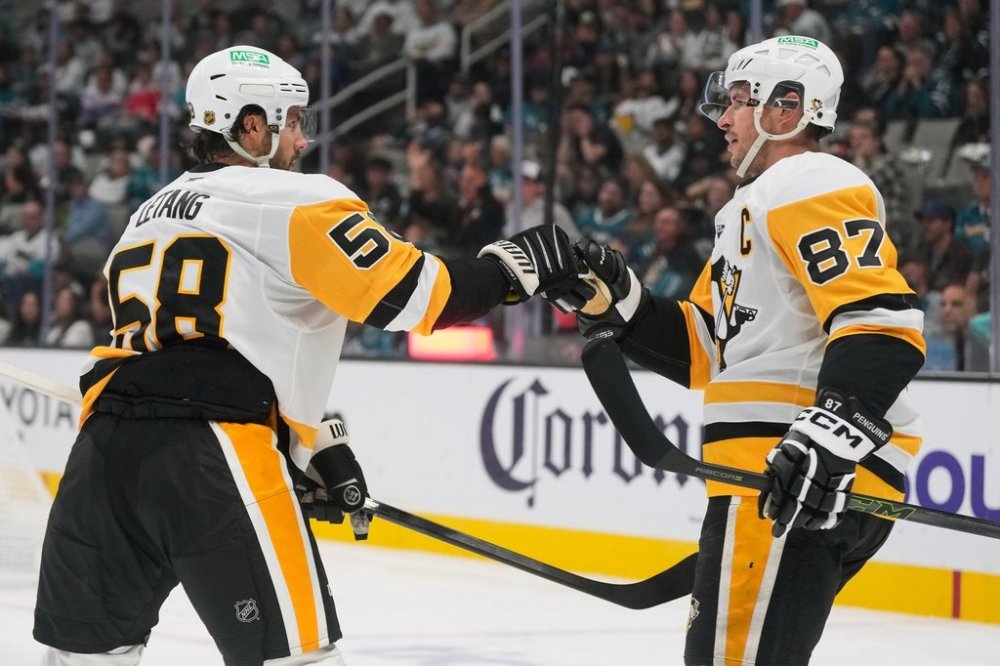 Pittsburgh Penguins center Sidney Crosby (87) is congratulated by defenseman Kris Letang (58) after scoring against the San Jose Sharks during the second period of an NHL hockey game in San Jose, Calif., Saturday, Oct. 18, 2025. (AP Photo/Jeff Chiu)