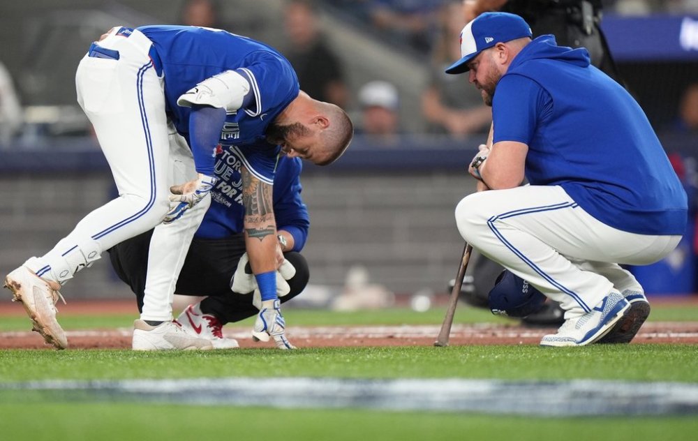 Blue Jays manager John Schneider, right, talks with Nathan Lukes after he fouled a pitch off his right knee in the first inning of Game 1 of the American League Championship Series against the Seattle Mariners on Oct. 12, 2025. THE CANADIAN PRESS/Frank Gunn