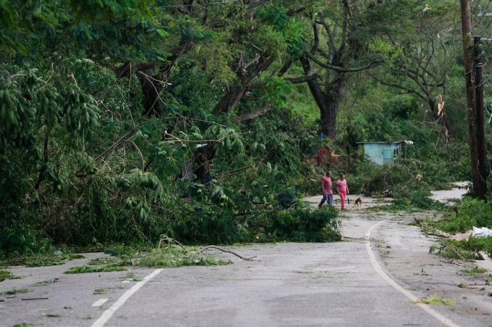 People walk along a road after Hurricane Melissa passed through Spurr Tree, Jamaica, Wednesday, Oct. 29, 2025. (AP Photo/Matias Delacroix),