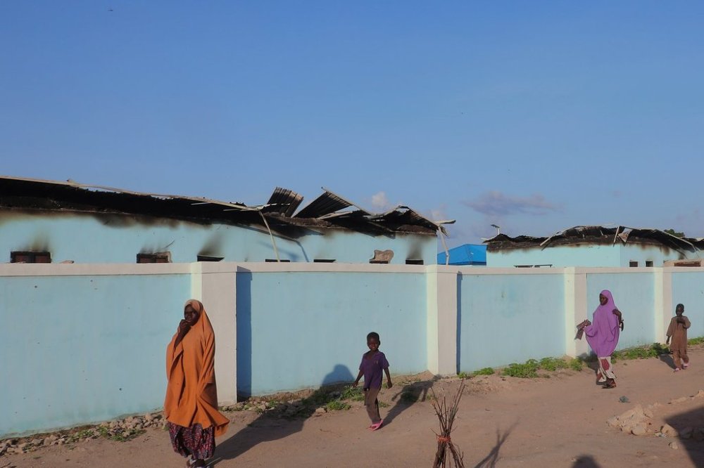 FILE - People walk past torched houses following an attack by Boko Haram in Darul Jamal, Nigeria, Saturday, Sept. 6, 2025. (AP Photo, File)