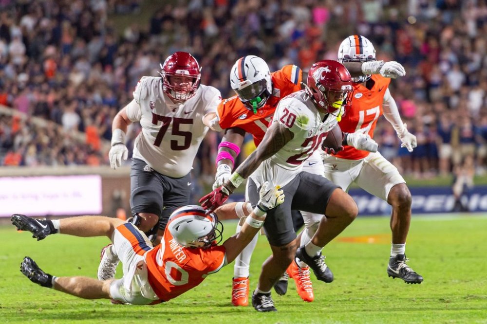 Virginia safety Ethan Minter (30) makes a tackle during a run by Washington State running back Leo Pulalasi (20) during the first half of an NCAA college football game, Saturday, Oct. 18 2025, in Charlottesville, Va. (AP Photo/Robert Simmons)