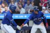 Toronto Blue Jays' Andrés Giménez, left, and teammate Ernie Clement celebrate at home plate after Clements scored on a sacrifice fly from Giménez against the Tampa Bay Rays during fourth inning MLB baseball action in Toronto on Sunday Sept. 28, 2025. THE CANADIAN PRESS/Chris Young