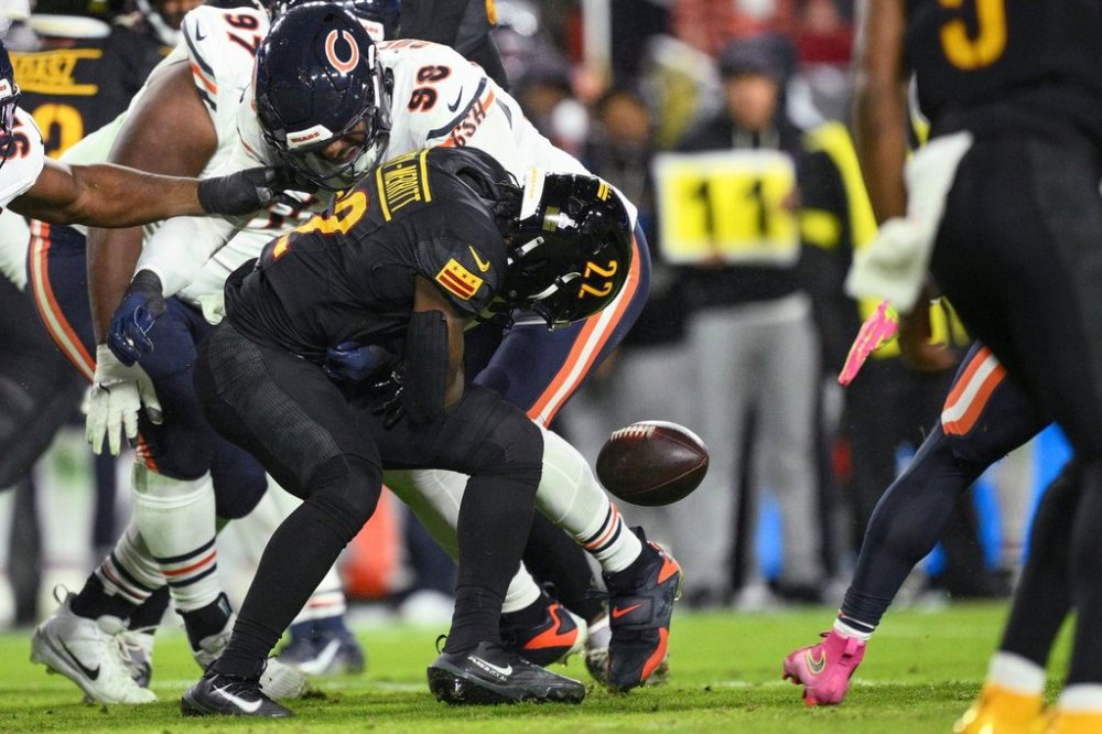 Washington Commanders running back Jacory Croskey-Merritt (22)fumbles the ball as he is hit by Chicago Bears defensive end Montez Sweat (98) during the first half of an NFL football game Monday, Oct. 13, 2025, in Landover, Md. (AP Photo/Nick Wass)