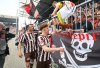 FILE - St. Pauli players Philipp Treu, right, and Manolis Saliakas high-five with the fans after a Bundesliga soccer match between FC St. Pauli and VfL Bochum, May 17, 2025, in Hamburg, Germany. (Christian Charisius/dpa via AP, File)