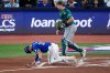 Toronto Blue Jays' Nathan Lukes is slow to get up after fouling the ball off his leg as Seattle Mariners catcher Cal Raleigh, right, looks away during the first inning in Game 1 of baseball's American League Championship Series, Sunday, Oct. 12, 2025, in Toronto. (AP Photo/David J. Phillip)