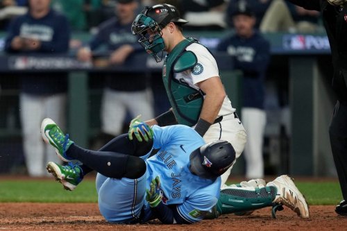 Toronto Blue Jays' George Springer falls after being hit by a pitch against the Seattle Mariners during the seventh inning in Game 5 of baseball's American League Championship Series, Friday, Oct. 17, 2025, in Seattle. (AP Photo/Abbie Parr)