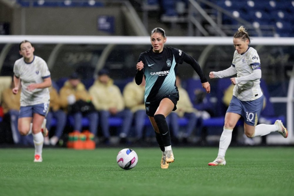 FILE - NJ/NY Gotham FC forward Sarah Schupansky dribbles the ball with Seattle Reign FC midfielder Angharad James-Turner, left, and midfielder Jess Fishlock, right, defending during an NWSL soccer match in Seattle, Saturday, March 15, 2025. (AP Photo/John Froschauer,File)