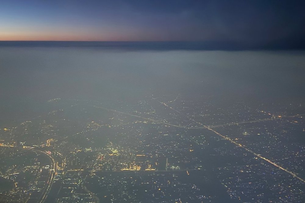A layer of smog hangs over the skyline as seen from an aircraft window in New Delhi, India, Saturday, Oct. 25, 2025. (AP Photo/Yirmiyan Arthur)