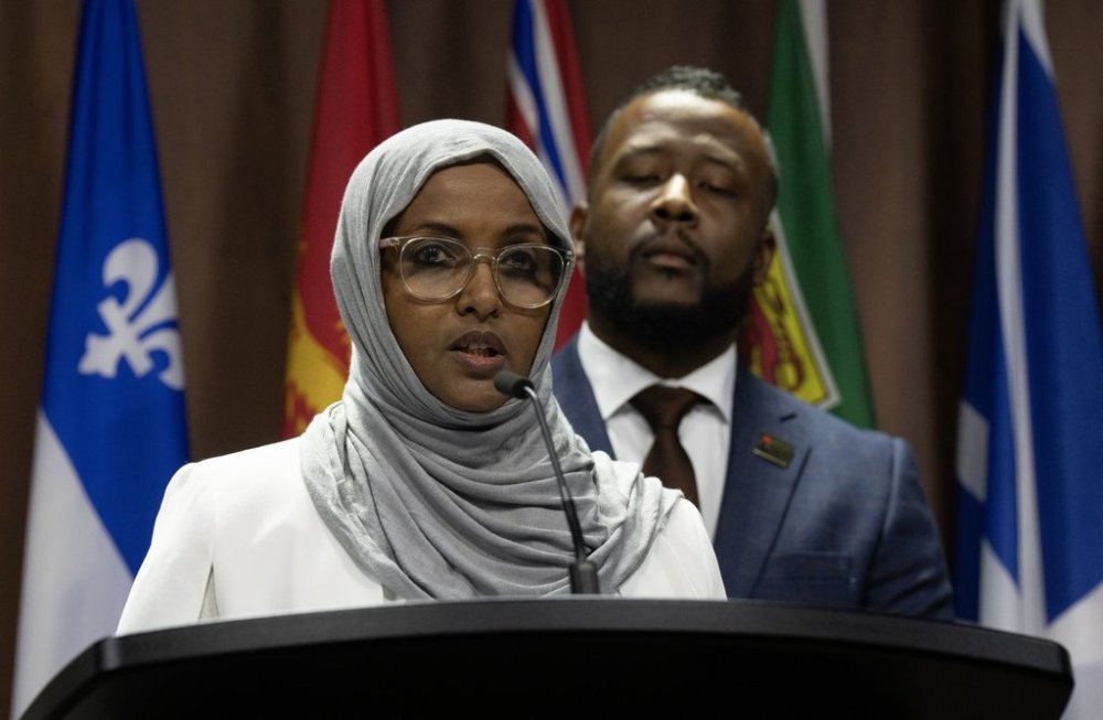 President and CEO of the Black Class Action Secretariat Nicholas Marcus Thompson looks on as Global Affairs Canada employee Madina Iltireh speaks during a news conference in Ottawa on Wednesday, Oct. 22, 2025. THE CANADIAN PRESS/Adrian Wyld