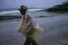 A man walks in the rain before the arrival of Hurricane Melissa in Canizo, a community in Santiago de Cuba, Tuesday, Oct. 28, 2025. (AP Photo/Ramón Espinosa)