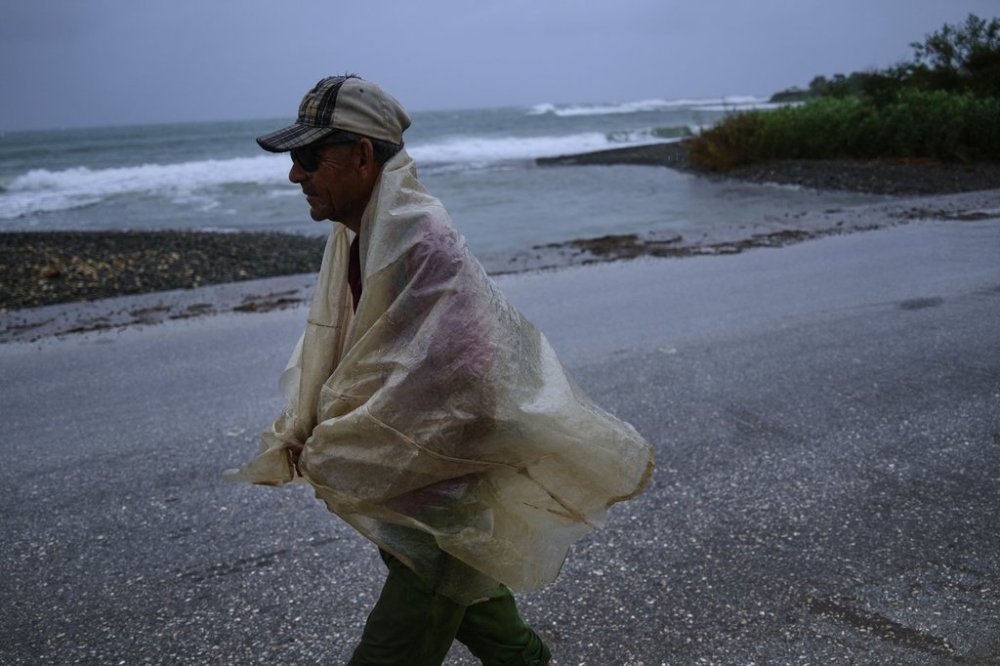 A man walks in the rain before the arrival of Hurricane Melissa in Canizo, a community in Santiago de Cuba, Tuesday, Oct. 28, 2025. (AP Photo/Ramón Espinosa)