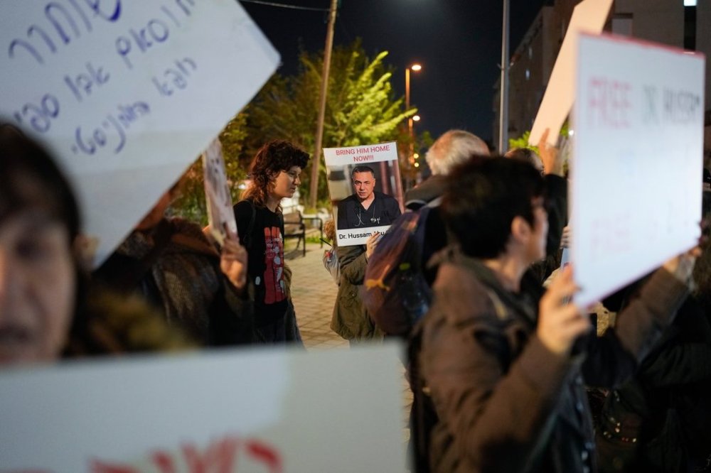 FILE - A woman holds a sign with a photo of Palestinian Dr. Hussam Abu Safiya during a protest calling for his release in front of the Shin Bet offices in Tel Aviv, Israel, Jan. 1, 2025. (AP Photo/Matias Delacroix, File)