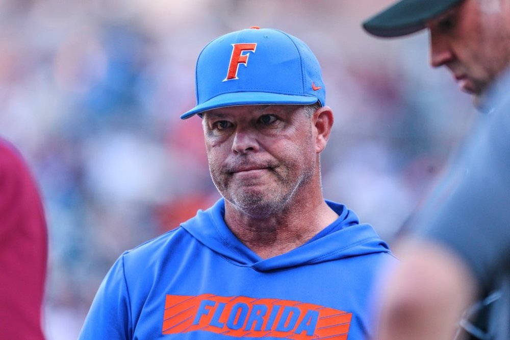 FILE - Florida head coach Kevin O'Sullivan meets with officials before an NCAA baseball game against Florida State in Jacksonville, Fla., Tuesday, March 25, 2025. (AP Photo/Gary McCullough, File)