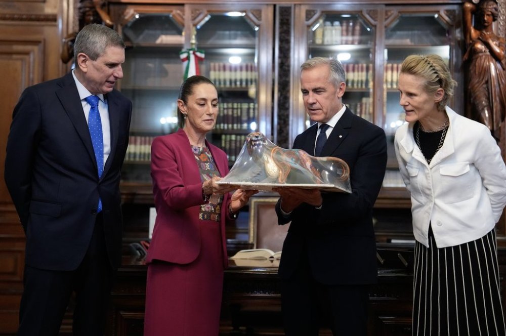 Jesus Maria Tarriba, left, and Diana Fox Carney, right, look on as Mexican President Claudia Sheinbaum presents a gift to Prime Minister Mark Carney at the National Palace in Mexico City on Thursday, Sept. 18, 2025. THE CANADIAN PRESS/Adrian Wyld