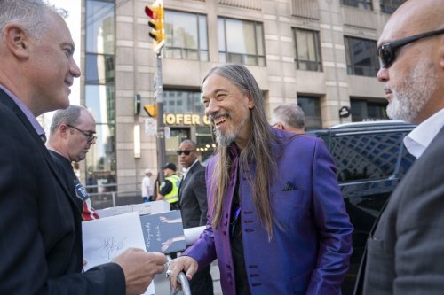 The Tragically Hip's Rob Baker signs a fan's poster after a public sing-along with Choir! Choir! Choir! at the Toronto International Film Festival, in Toronto, on Thursday Sept. 5, 2024. THE CANADIAN PRESS/Paige Taylor White