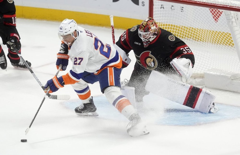 New York Islanders left wing Anders Lee (27) stick handles the puck in front of Ottawa Senators goaltender Linus Ullmark (35) during third period NHL action in Ottawa, Saturday, Oct. 18, 2025. THE CANADIAN PRESS/Adrian Wyld