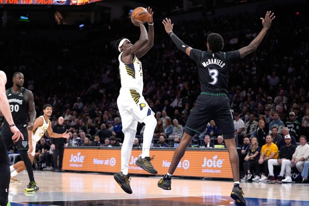 Indiana Pacers forward Pascal Siakam, center, goes up to shoot over Minnesota Timberwolves forward Jaden McDaniels (3) during the first half of an NBA basketball game, Sunday, Oct. 26, 2025, in Minneapolis. (AP Photo/Abbie Parr)